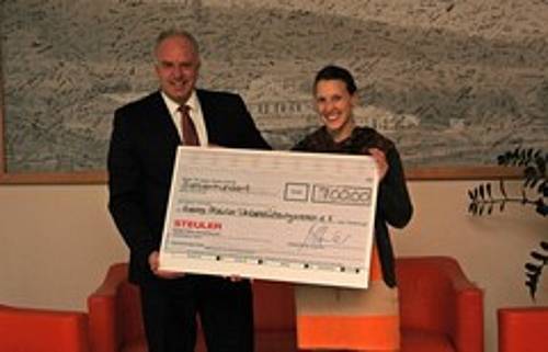 Andreas Grimm and Janina Duch hold the donation check for the Georg Steuler Support Association