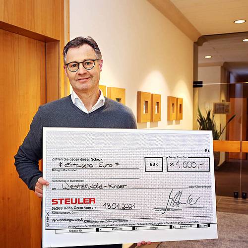 Managing director Michael Steuler holds the donation check for the Westerwaldkinder