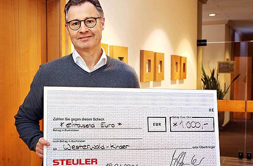 Managing director Michael Steuler holds the donation check for the Westerwaldkinder